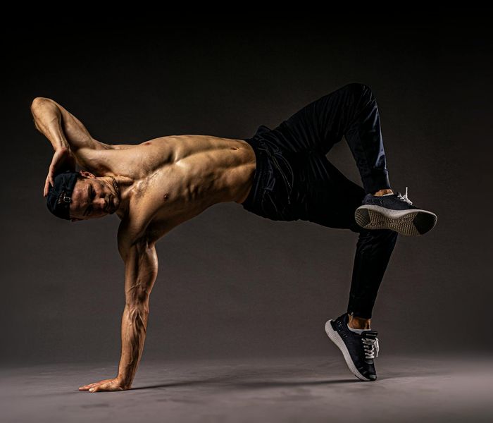 Man demonstrating flexibility and strength in a studio.